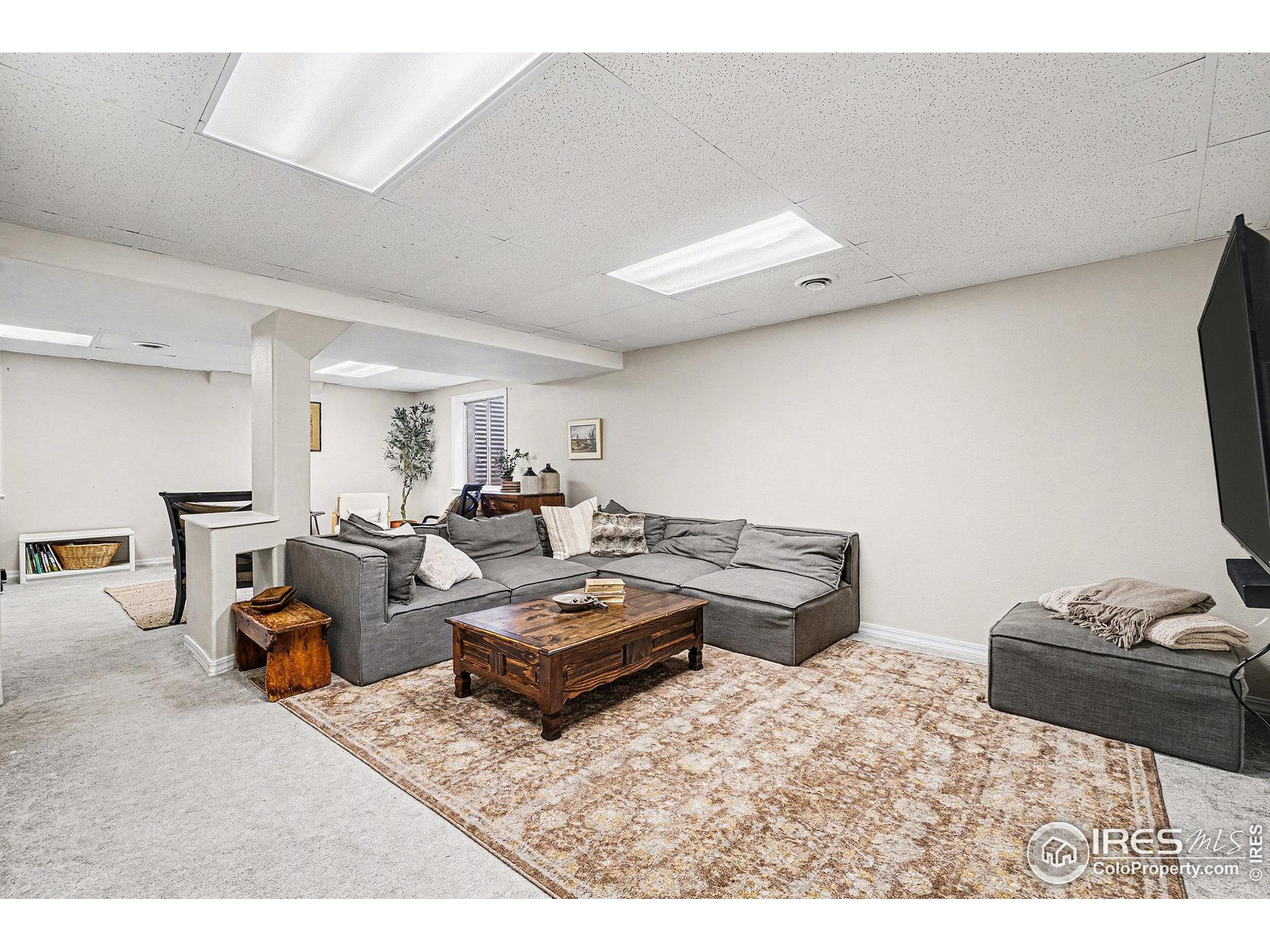 1244 Spring Creek Court Longmont, CO 80504 - Photo 20 of 32 a living room with furniture a air conditioner and a table