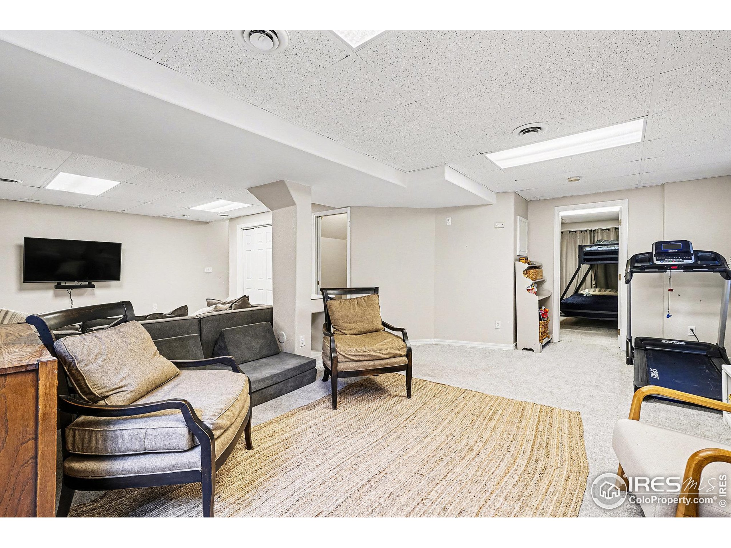 1244 Spring Creek Court Longmont, CO 80504 - Photo 21 of 32 a living room with furniture and a flat screen tv