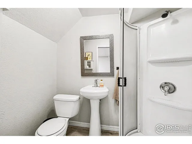 a bathroom with a toilet a sink and mirror