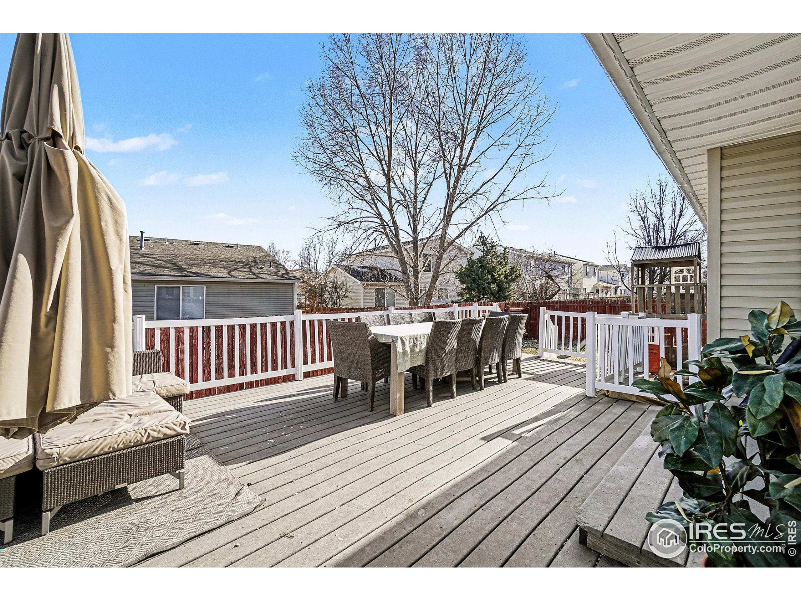 1244 Spring Creek Court Longmont, CO 80504 - Photo 30 of 32 a balcony with wooden floor table and chairs