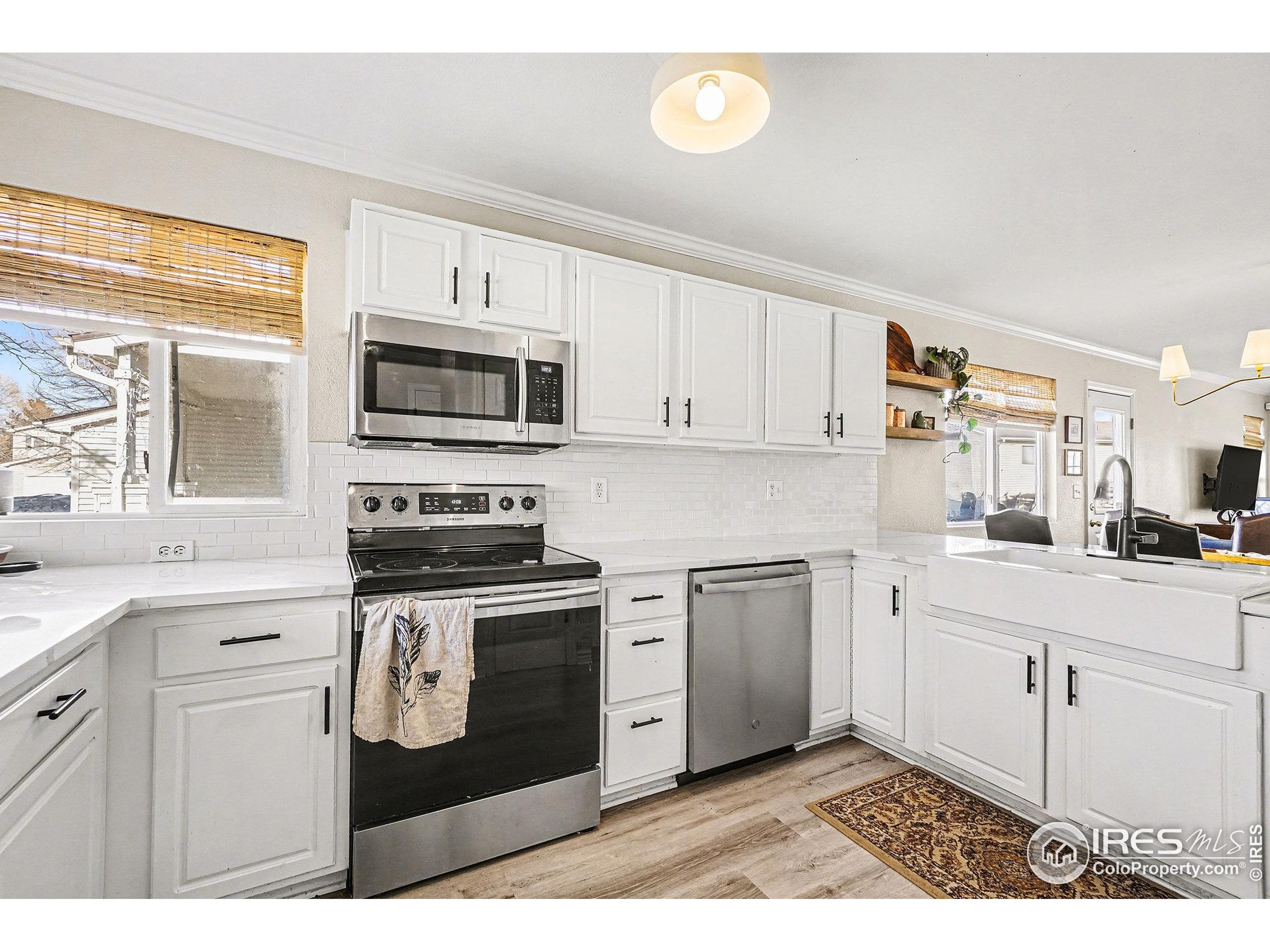 1244 Spring Creek Court Longmont, CO 80504 - Photo 4 of 32 a kitchen with stainless steel appliances granite countertop a stove a sink and a microwave