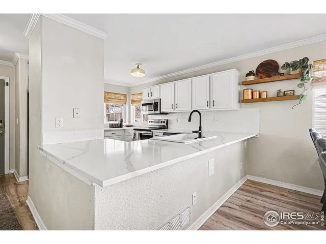 a kitchen with stainless steel appliances a sink a stove and white cabinets