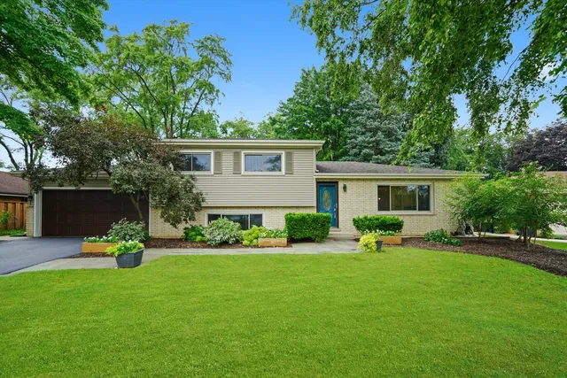 a front view of house with a garden and trees