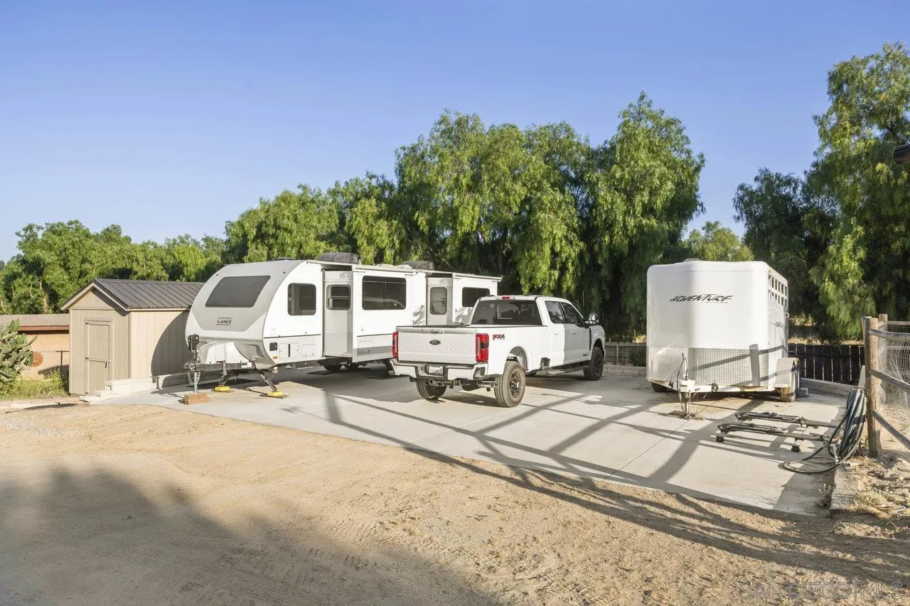 2952 Milpas Drive Escondido, CA 92029 - Photo 28 of 33 a white house with tall trees in front of it