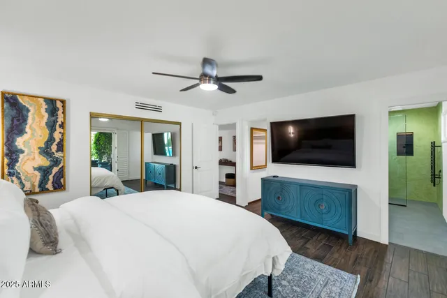 a bedroom with a bed and a flat screen tv