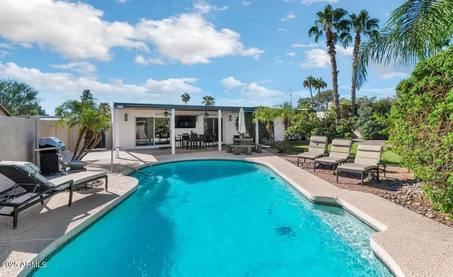 a view of a swimming pool with chairs and a table