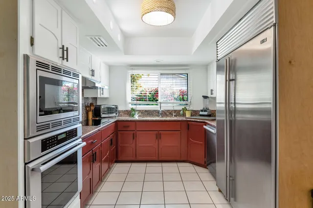 a kitchen with stainless steel appliances granite countertop a refrigerator and a sink