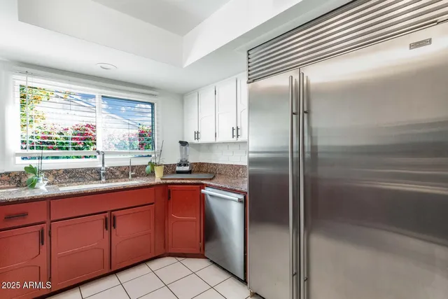 a kitchen with a sink refrigerator and window
