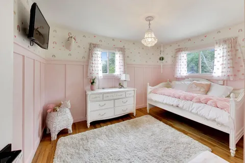 a bedroom with bed and flat tv screen on dresser