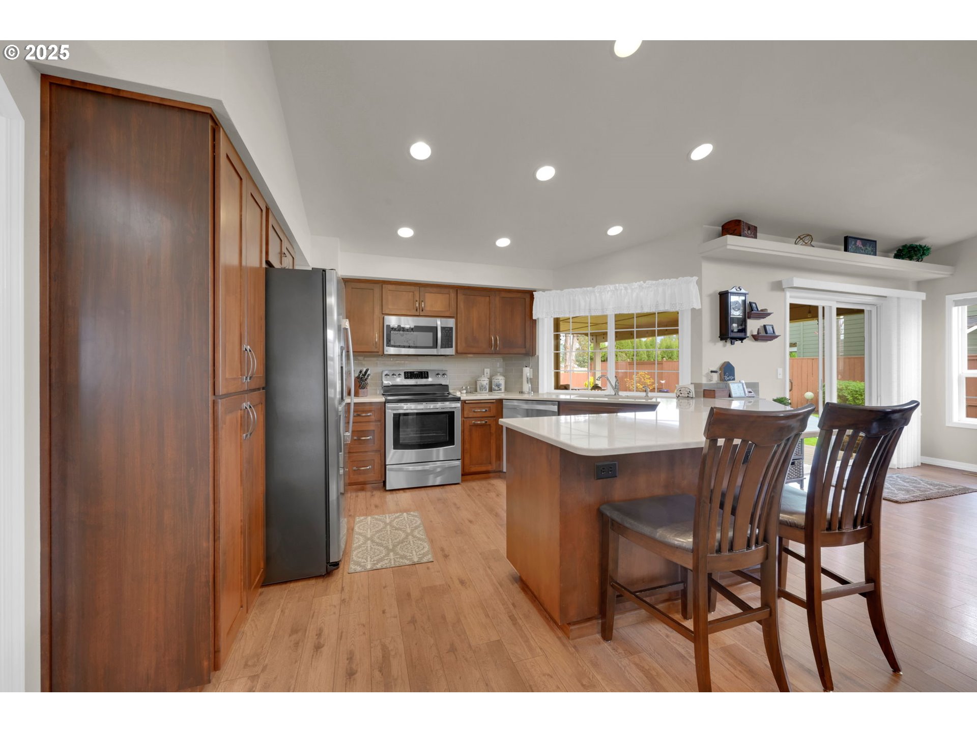 2458 Otto Street Springfield, OR 97477 - Photo 11 of 37 a kitchen with stainless steel appliances kitchen island granite countertop a refrigerator a stove a sink dishwasher with a dining table and chairs