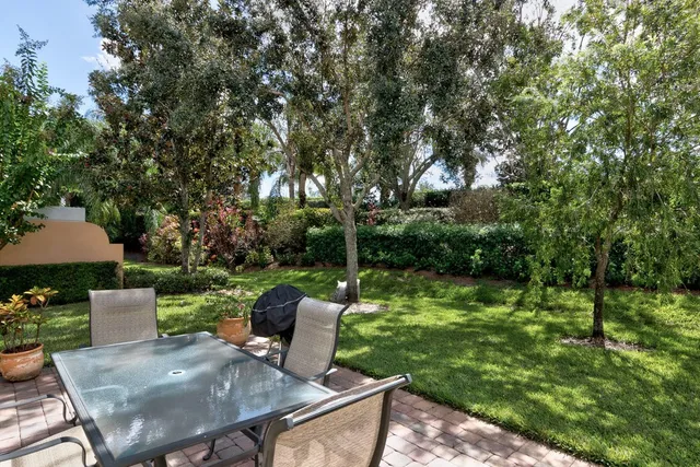 a view of a patio with table and chairs potted plants with large tree