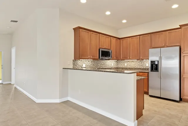 a kitchen with kitchen island a counter top space cabinets and stainless steel appliances