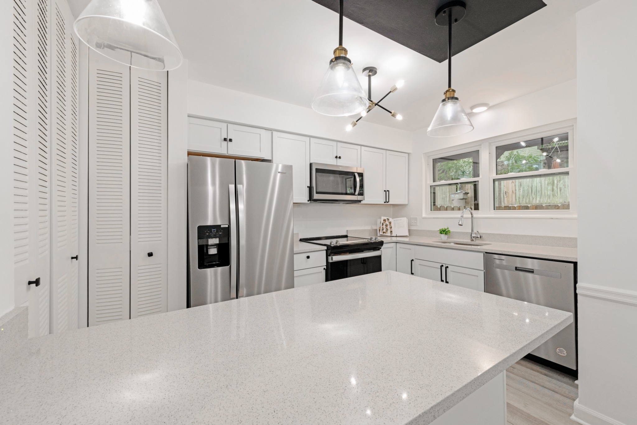 4000 Anderson Road, Unit 12 Nashville, TN 37217 - Photo 9 of 28 a kitchen with granite countertop a refrigerator oven a sink dishwasher and white cabinets with wooden floor