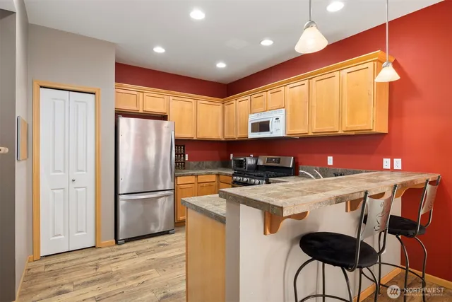 a kitchen with a refrigerator a stove a sink and a microwave