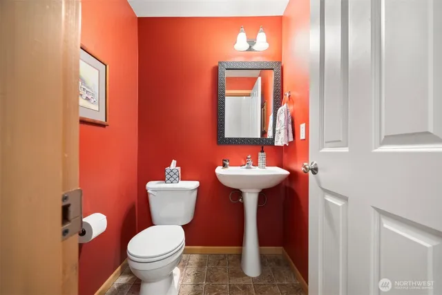 a bathroom with a sink mirror and toilet