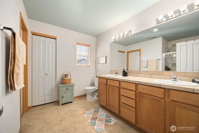 a spacious bathroom with a double vanity sink a mirror and a bathtub