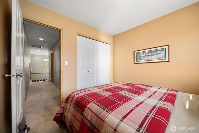 a bedroom with a bed and painting on the wall