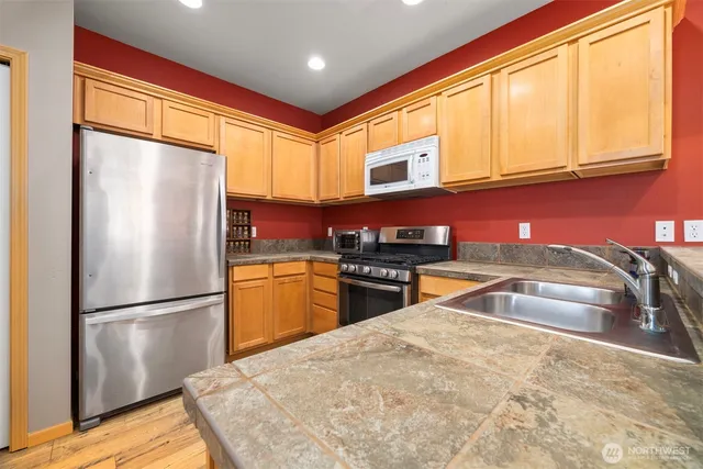 a kitchen with stainless steel appliances granite countertop a refrigerator sink and cabinets