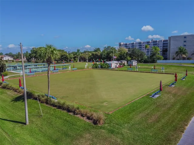 an aerial view of a residential houses with outdoor space and trees