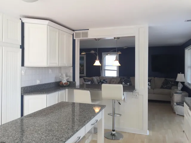 a kitchen with granite countertop a sink and a stove top oven