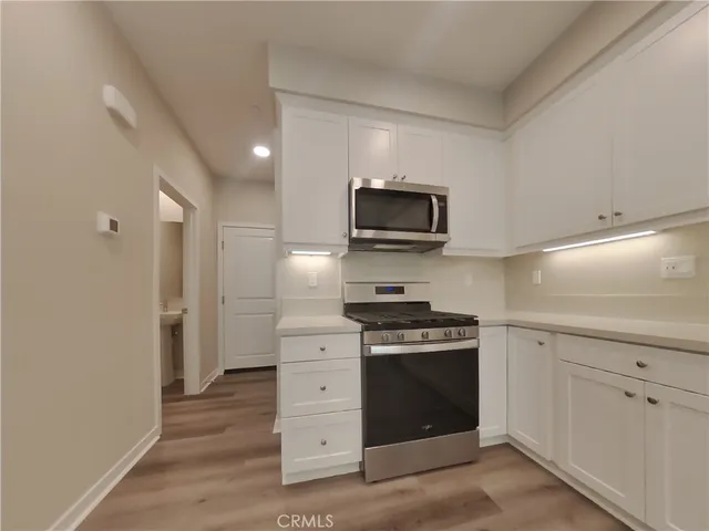 a kitchen with stainless steel appliances a stove microwave and refrigerator