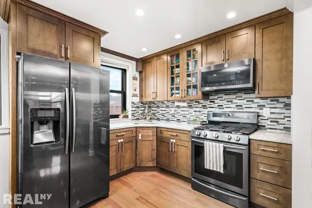 a kitchen with stainless steel appliances granite countertop a stove a refrigerator and a sink