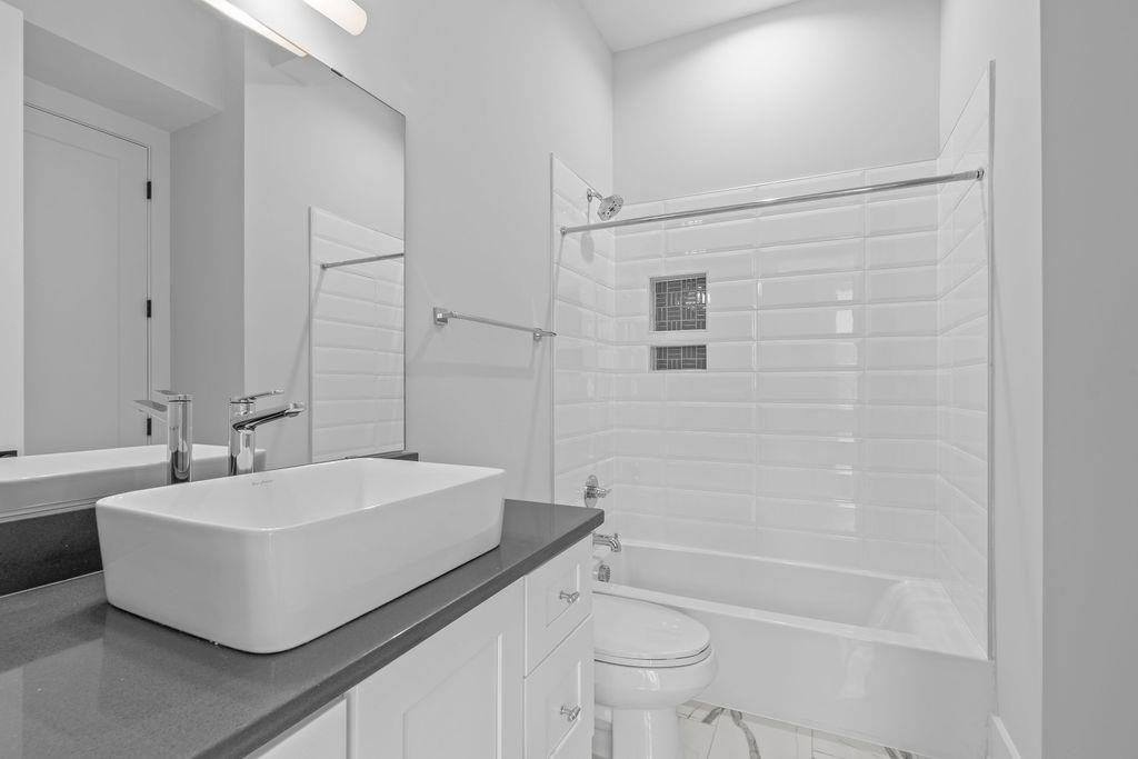 617 South West Street Raleigh, NC 27601 - Photo 21 of 44 a bathroom with a sink a toilet and shower