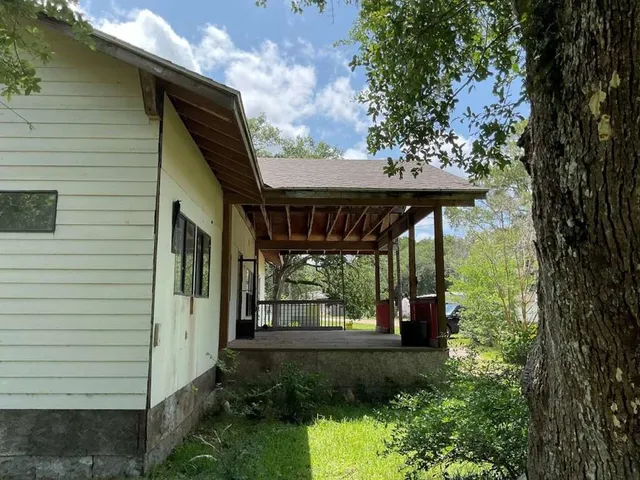 a view of a patio with table and chairs potted plants and floor to ceiling window