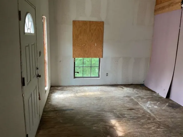 an empty room with windows and mirror