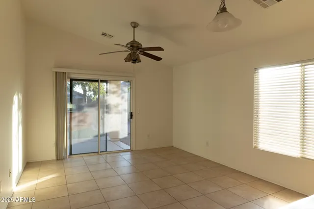 a view of an empty room and window chandelier fan