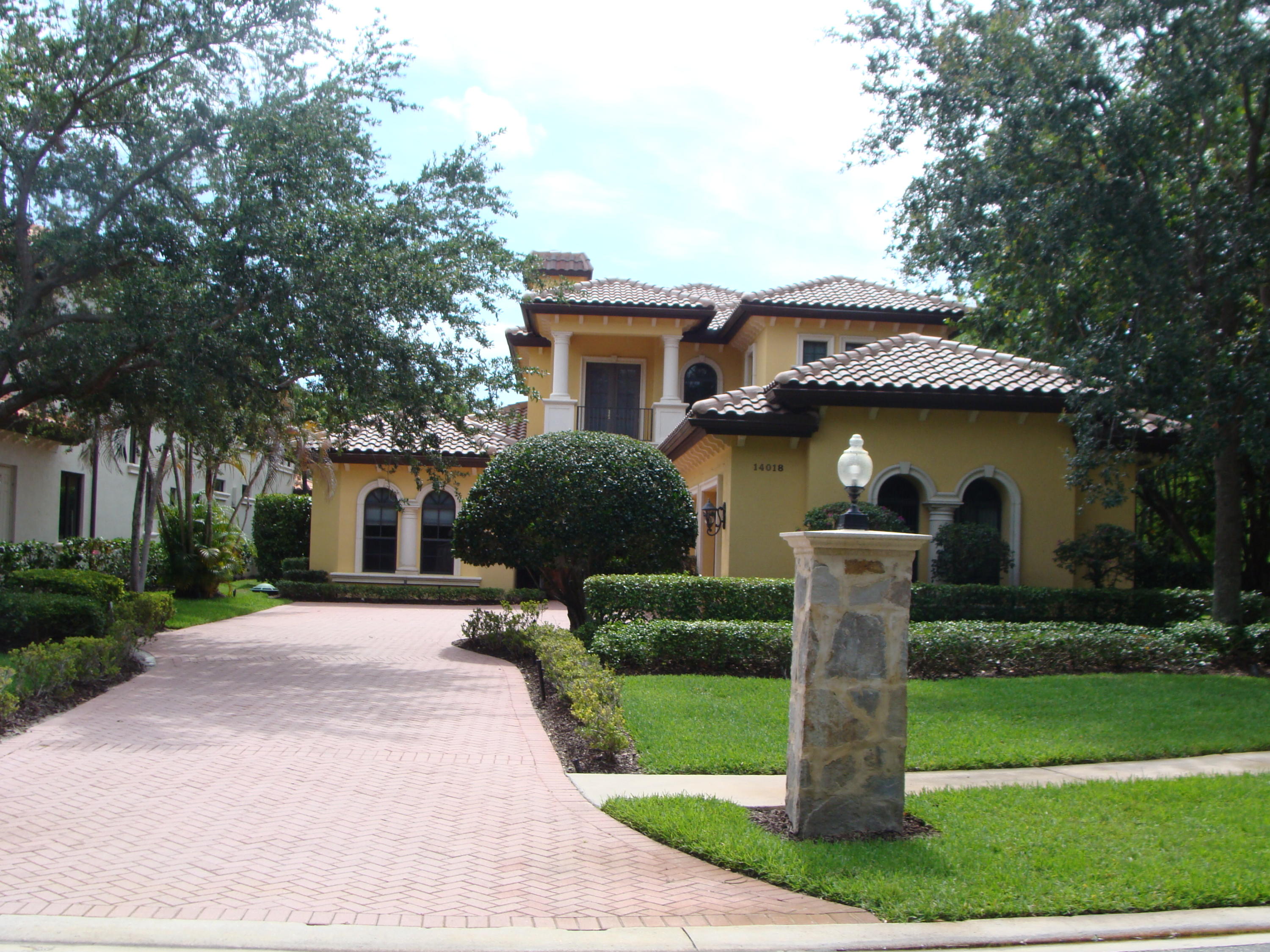 a front view of a house with a yard and fountain