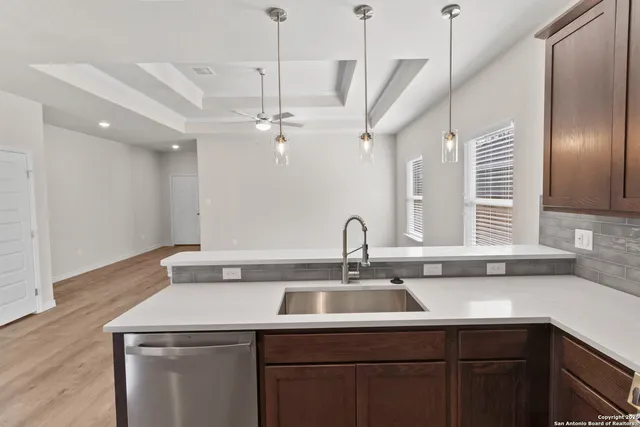 a view with a sink a counter space and cabinets
