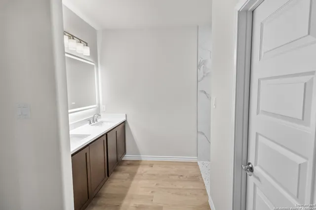 a bathroom with a granite countertop sink and a mirror
