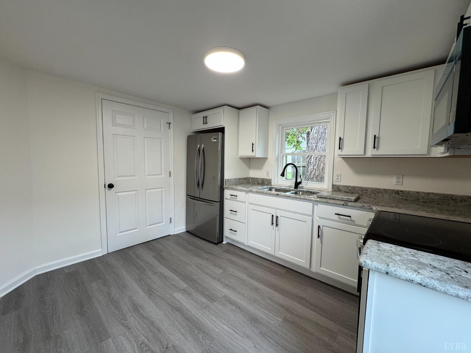287 Harrell Street Appomattox, VA 24522 - Photo 8 of 17 a kitchen with a refrigerator sink and cabinets