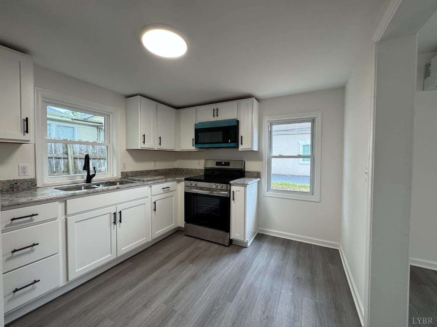 287 Harrell Street Appomattox, VA 24522 - Photo 10 of 17 a kitchen with granite countertop a stove a sink and a microwave