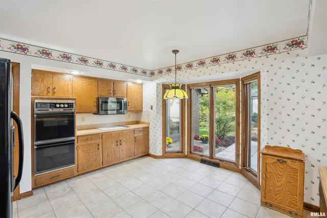 a large kitchen with a stove a refrigerator and a sink