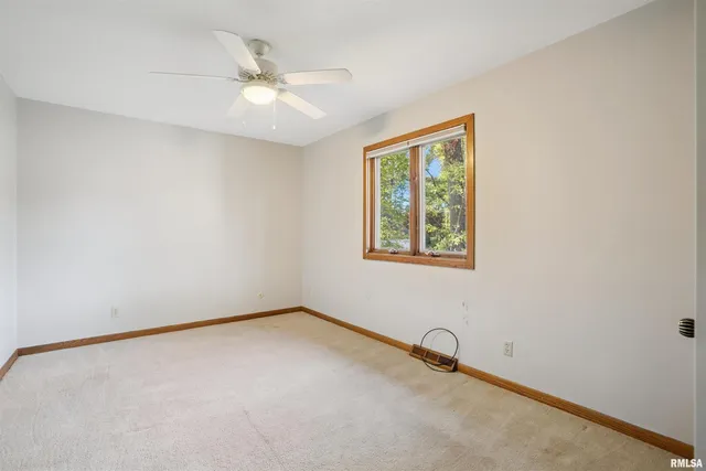 an empty room with a window and a ceiling fan
