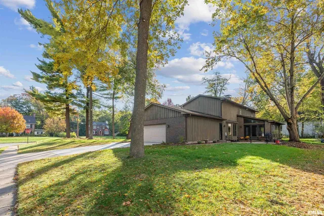 a view of a house with a big yard and large tree