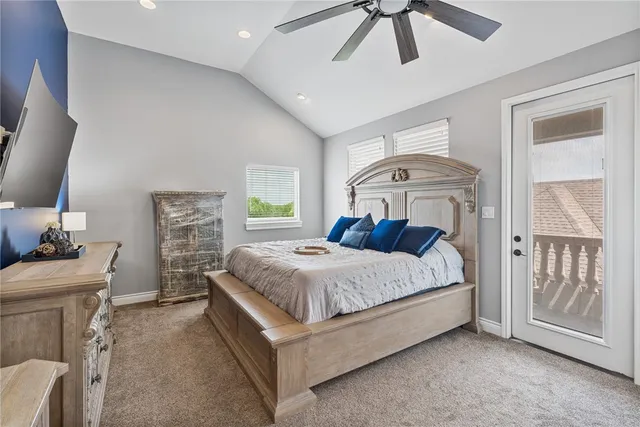 a bedroom with a bed ceiling fan and a wooden floor