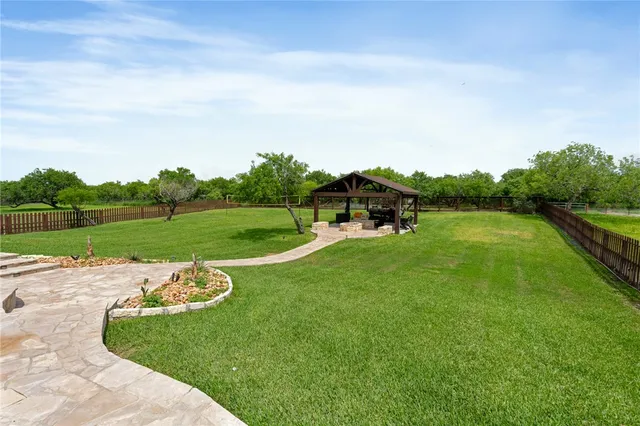 a view of a patio with table and chairs barbeque grill and a small yard