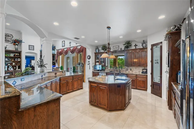a kitchen with stainless steel appliances granite countertop a sink a stove and a wooden cabinets