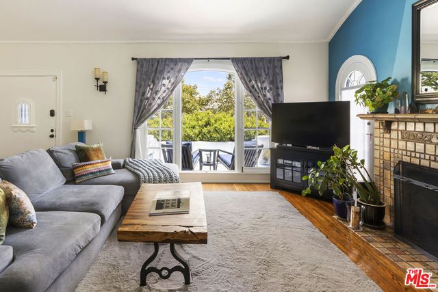 a living room with furniture a flat screen tv and a large window