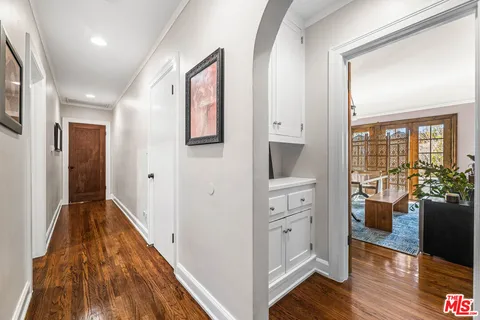a view of hallway with furniture and wooden floor