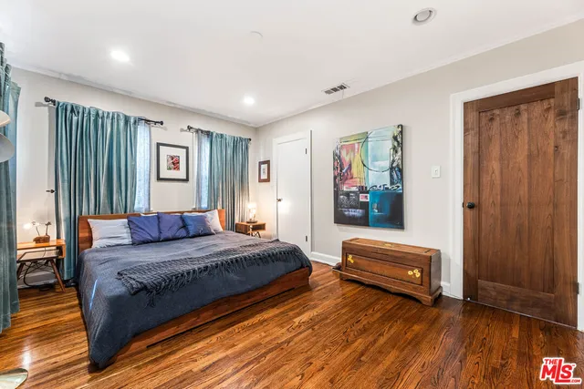 a bedroom with a bed and a painting on the wall