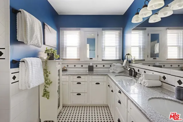 a bathroom with a granite countertop sink a mirror a vanity and a shower