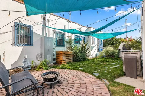 a backyard of a house with a fountain table and chairs