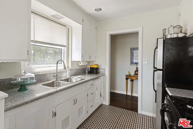 a kitchen with granite countertop a sink stainless steel appliances and cabinets