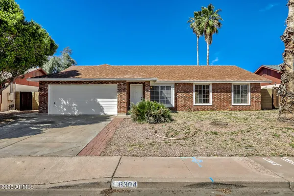 a front view of a house with a yard and a garage