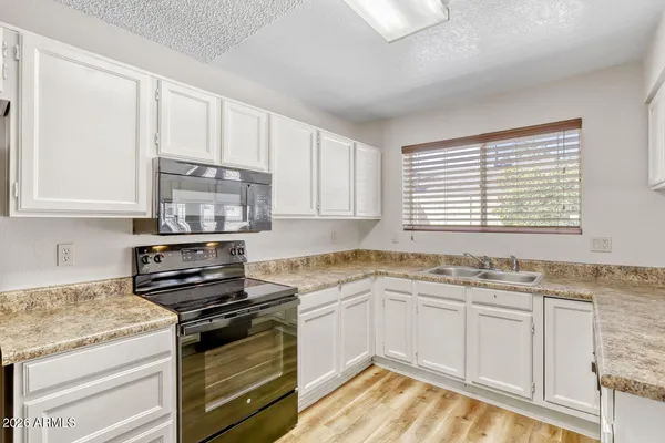 a kitchen with stainless steel appliances granite countertop a sink stove cabinets and a window