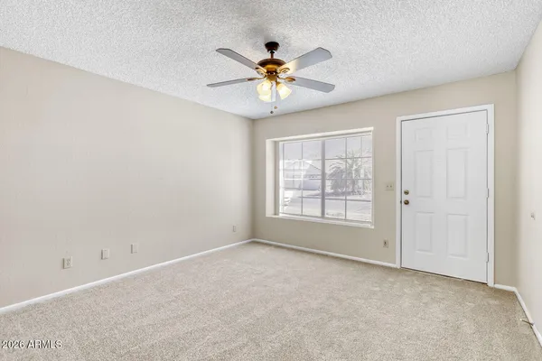 a view of a livingroom with a ceiling fan and window